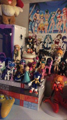 a bunch of toy figurines sitting on top of a pile of books next to a teddy bear