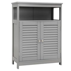 a gray cabinet with shutter doors on the top and bottom shelf, in front of a white background