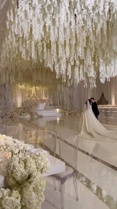 the bride and groom are standing under an elaborate chandelier