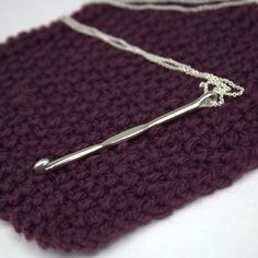 a crocheted purple bag with a silver handle