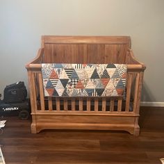 a wooden crib with a quilt on it