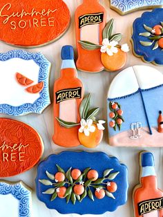 decorated cookies with orange and blue accents on a white tablecloth that says,'summer soiree '