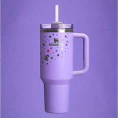 a purple travel mug with stars and unicorns on the side, is shown against a lila background