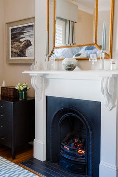 a living room with a fire place and a mirror on the wall above it's mantle