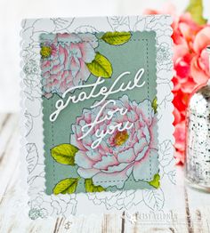 a close up of a card on a table with flowers