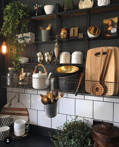 a kitchen counter with pots and pans on the shelves above it is filled with cooking utensils