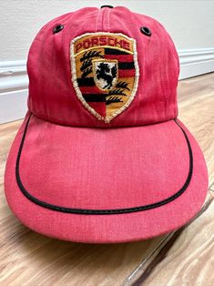 This rare vintage Porsche cotton fitted 7 1/8 hat is a must-have for any Porsche enthusiast. With its classic red beautifully faded / patina and late 50's early 60's design, this baseball cap is a great addition to any collection. Made with high-quality cotton material, this hat is both stylish and comfortable to wear. It features the iconic Porsche brand logo on the front and is perfect for any occasion. Whether you're going for a casual look or dressing up for a formal event, this hat is sure to turn heads. Don't miss out on the opportunity to own a piece of Porsche history. Estate sale from avid vintage Porsche SoCal collector. No holes or tears, cracks as can be seen in photos and excellent condition sweatband. Vintage Snapback Fitted Hat, Vintage Red Six-panel Baseball Cap, Vintage Flat Bill Baseball Cap, Vintage Red Snapback Fitted Hat, Vintage Red Six-panel Hat, Retro Red Visor Baseball Cap, Vintage Six-panel Adjustable Fitted Hat, Vintage Red Hat With Flat Bill, Vintage Red Flat Bill Baseball Cap