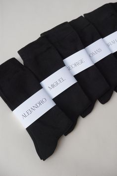 five pairs of black socks with white ribbons