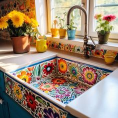 a kitchen sink with colorful flowers painted on the front and side, next to a window