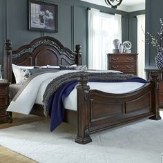 a bedroom with a bed, dresser and night stand in it's center area