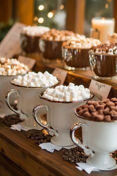 hot chocolates and marshmallows in white cups on a table