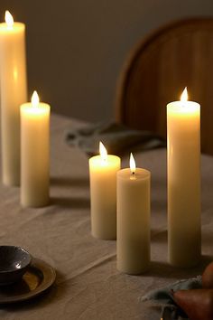 five lit candles sitting on top of a table