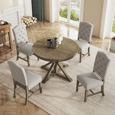 a round table with four chairs around it on a rug in front of a window