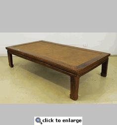 a wooden coffee table sitting on top of a hard wood floor covered in white paint