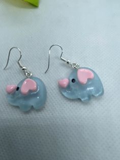 SHIP WITHIN US ONLY THXSuper cute pale blue elephants, clear coated. Have pink heart shaped ears and cute pink heart on end of their trunk. Adorable baby elephant charms. I added surgical steel ear wires to make these cute lightweight earrings. All materials used are marked nickel free. Theses resin charms are lightweight.  These are new hand crafted  Local regulations do not allow returns on pierced jewelry  I ship daily via first class mail with tracking. I do combine orders to cut your postal cost Please reach out to me with any questions and thank you for looking. Check out my other listings for fun , unique earrings. And there are more elephant's.PLEASE NOTE:  I only ship within the USA   Current postal rates  and lack of reliable tracking on international orders makes it impossible Cute Pink Heart, Earrings Hearts, Elephant Earrings, Blue Elephant, Elephant Charm, Pierced Jewelry, Blue Elephants, Resin Charms, Lightweight Earrings