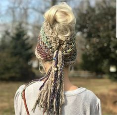 a woman with blonde hair wearing a multicolored knitted headband and scarf