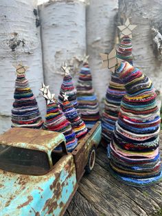 an old truck is decorated with colorful trees