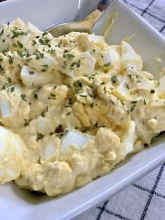 an egg salad in a white dish on a table