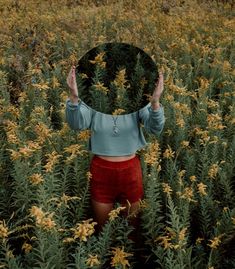 a woman standing in a field with her hands up