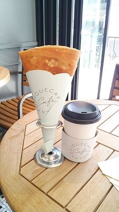 a table that has some coffee cups on it and a cake in the shape of a cone