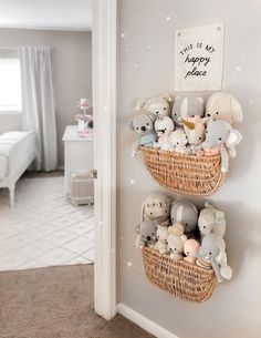 two baskets filled with stuffed animals on top of a wall next to a bed in a bedroom