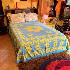 a bed in a bedroom with yellow walls and wooden flooring, along with two lamps on either side of the bed