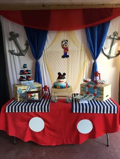 a mickey mouse themed birthday party with red, white and blue table cloths on it