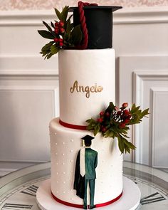 a white and red wedding cake with two people on top