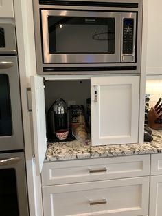 a microwave oven sitting on top of a white cabinet in a kitchen next to an oven