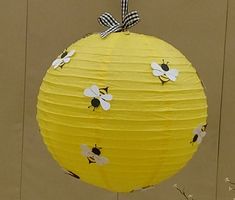 a yellow paper lantern with bees on it