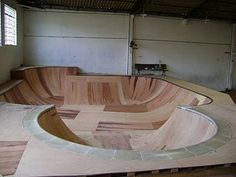 a wooden skateboard ramp in a building with no one around it or on the ground