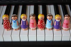 a group of wooden dolls sitting on top of a piano