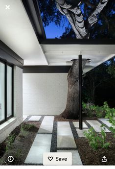 an image of a modern house at night with the lights on and trees in the background