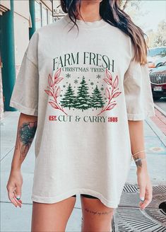 a woman wearing a farm fresh christmas tree t - shirt on her left arm and leg