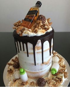 there is a cake that has been decorated with nuts and liquor on top, as well as other decorations