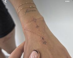 a woman's hand with a small star tattoo on it