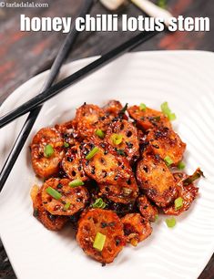 a white plate topped with fried food next to chopsticks