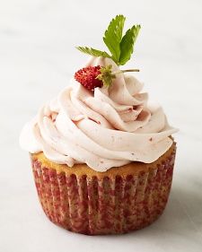 a cupcake with white frosting and a strawberry on top