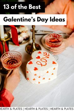 a white table topped with a cake and two wine glasses