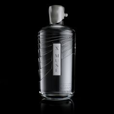 a bottle of cologne sitting on top of a black table next to a white object