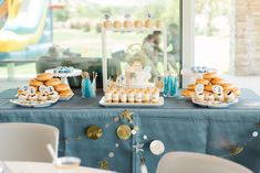 a blue table topped with lots of desserts