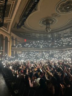 a large group of people holding up their cell phones in the air at a concert