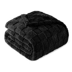 three black towels stacked on top of each other in front of a white background,