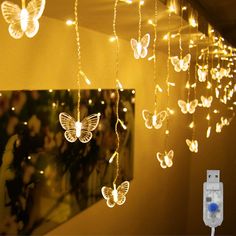 the butterfly string lights are hanging from the ceiling and have remote controls attached to them