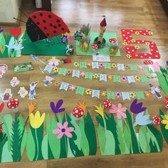 ladybug birthday party decorations on the floor with paper cutouts and streamers