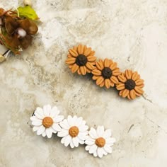 three flowers are sitting on a marble surface