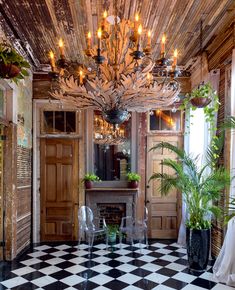 a chandelier hanging from the ceiling in a room with black and white checkered flooring