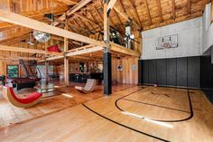 an indoor basketball court with wood flooring and wooden walls, surrounded by large windows