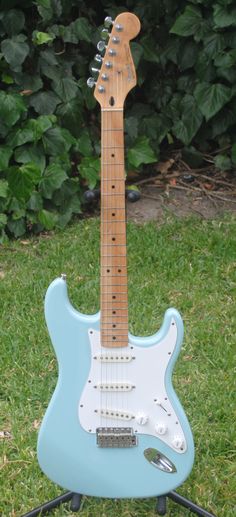 a blue guitar sitting on top of a green field