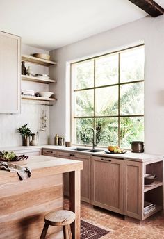 a kitchen with an open window and lots of counter space in front of the sink